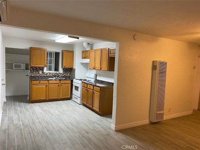 3352 Franklin Ave, Riverside, CA 92507 - kitchen with white range with gas cooktop, a heating unit, light wood-style flooring, brown cabinets, and baseboards