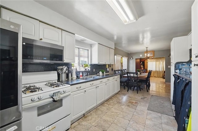12737 Cometa Ave, San Fernando, CA 91340 - kitchen featuring stainless steel microwave, white gas range oven, refrigerator, a chandelier, and white cabinetry