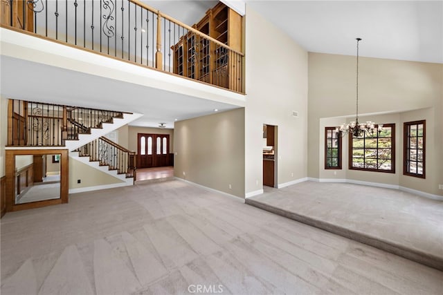 26021 Flintlock Ln, Laguna Hills, CA 92653 - unfurnished living room with a chandelier, carpet floors, stairway, a towering ceiling, and baseboards