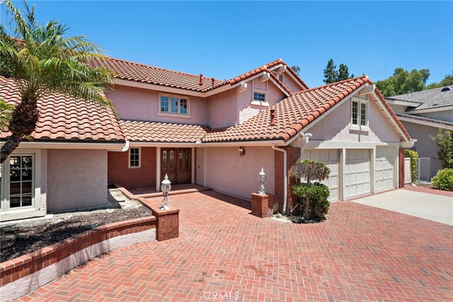 26021 Flintlock Ln, Laguna Hills, CA 92653 - mediterranean / spanish house featuring french doors, concrete driveway, stucco siding, and a garage