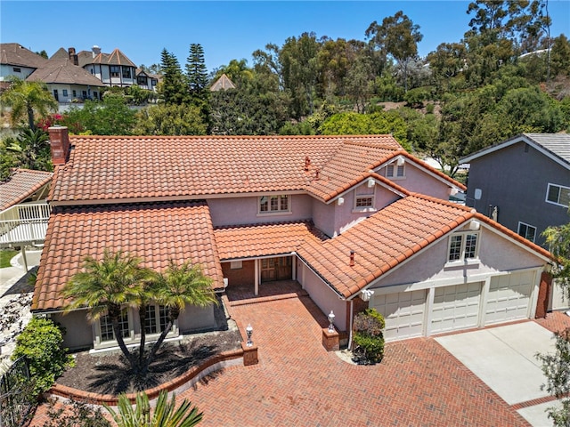 26021 Flintlock Ln, Laguna Hills, CA 92653 - mediterranean / spanish-style house with concrete driveway, a tiled roof, stucco siding, and a garage