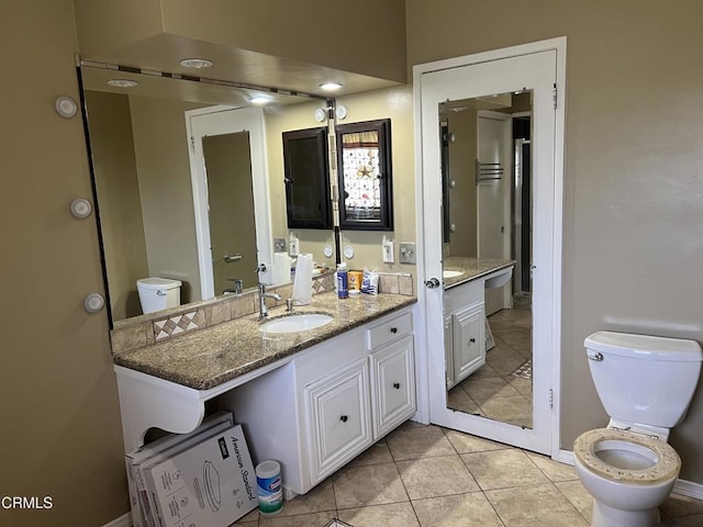 bathroom with toilet, tile patterned floors, and vanity