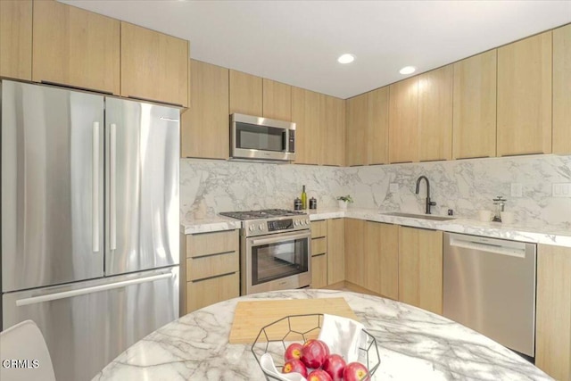 10720 Ohio Ave Unit 5, Los Angeles, CA 90024 - kitchen with stainless steel appliances, a sink, light brown cabinetry, decorative backsplash, and light stone countertops