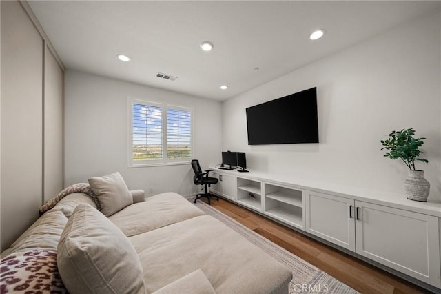 living area featuring wood finished floors, recessed lighting, and a desk