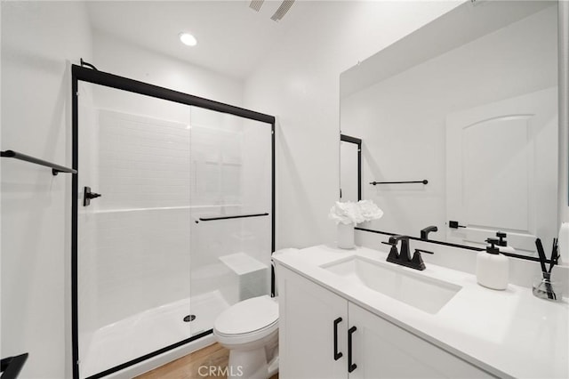 full bath featuring a stall shower, toilet, vanity, and recessed lighting
