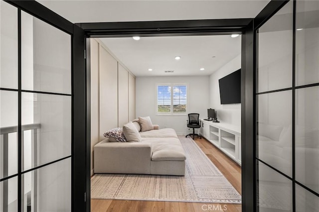 living area with light wood-type flooring and recessed lighting