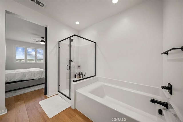 ensuite bathroom featuring a bath, a stall shower, ceiling fan, wood finished floors, and recessed lighting