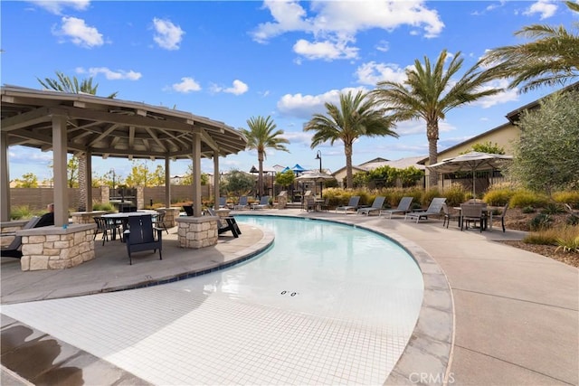 community pool with a gazebo and a patio