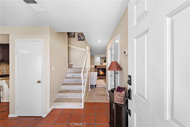 3340 E Collins Ave Unit 30, Orange, CA 92867 - stairs with tile patterned floors, a brick fireplace, recessed lighting, and baseboards