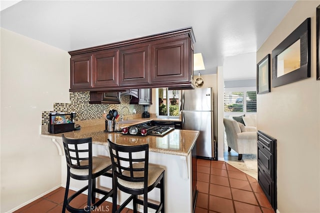 3340 E Collins Ave Unit 30, Orange, CA 92867 - kitchen featuring freestanding refrigerator, a peninsula, a sink, cooktop, and backsplash