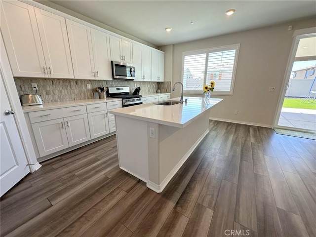 24555 Bravery Cir, Menifee, CA 92584 - kitchen with appliances with stainless steel finishes, a sink, dark wood-type flooring, decorative backsplash, and white cabinets