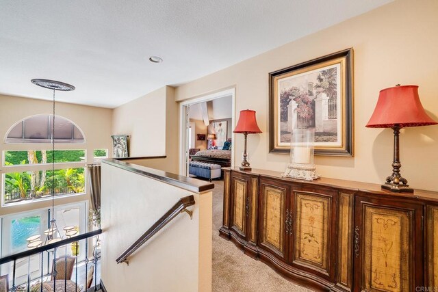 26395 Marsala Way, Mission Viejo, CA 92692 - hallway featuring light colored carpet, an upstairs landing, and a chandelier