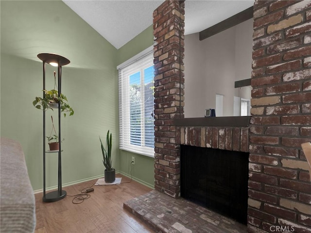 unfurnished living room with lofted ceiling, wood finished floors, a fireplace, and baseboards