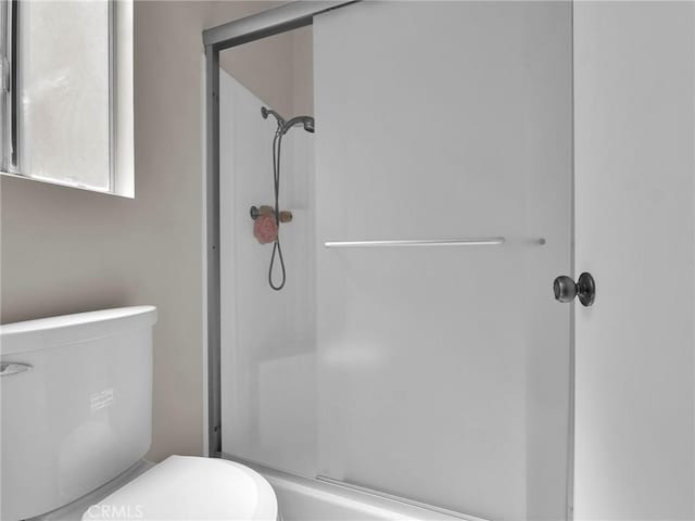 bathroom with a shower stall and toilet