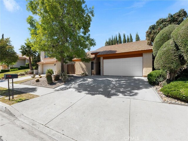 view of front of house featuring driveway, stucco siding, a garage, and a tile roof