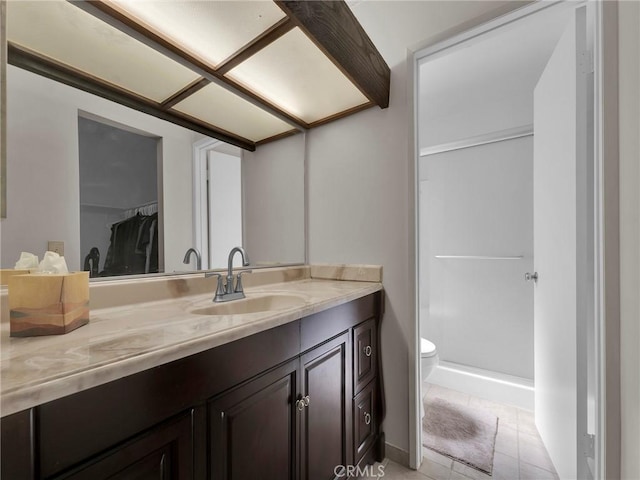 bathroom with toilet, vanity, and tile patterned flooring