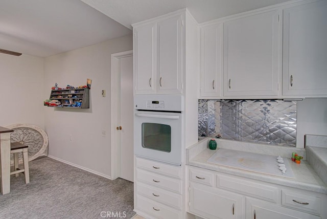 378 Avenida Castilla Unit O, Laguna Woods, CA 92637 - kitchen with white appliances, light countertops, white cabinets, and decorative backsplash