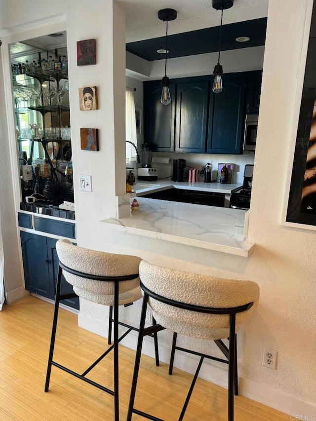 1355 N Sierra Bonita Ave Unit 204, West Hollywood, CA 90046 - bar area featuring a sink, gas stove, light wood-style floors, and baseboards