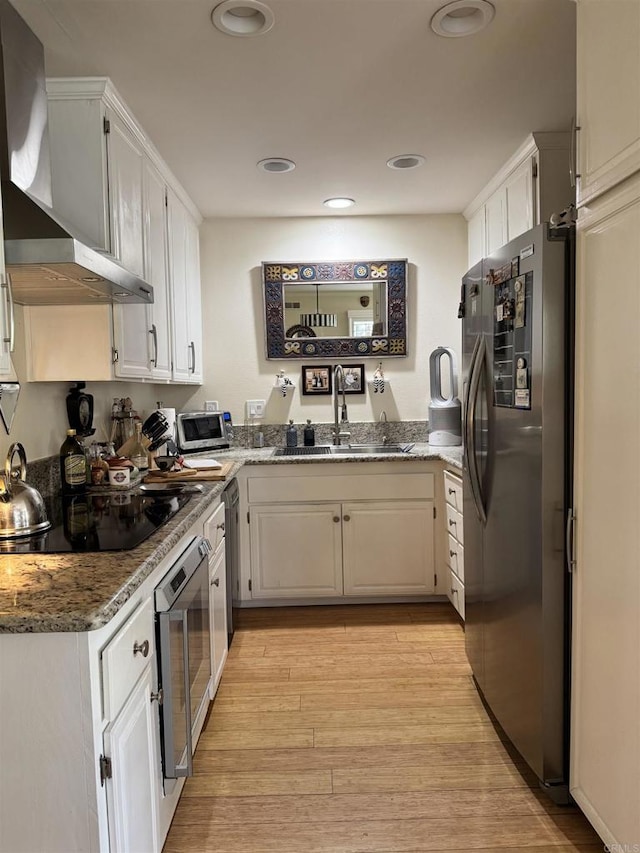 7975 Playmor Ter, San Diego, CA 92122 - kitchen with freestanding refrigerator, wall chimney exhaust hood, a sink, oven, and black electric stovetop