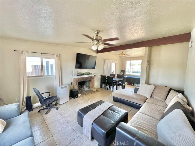 23079 Minnetonka Rd, Apple Valley, CA 92308 - living room with a textured ceiling, ceiling fan, light tile patterned floors, and a fireplace with raised hearth