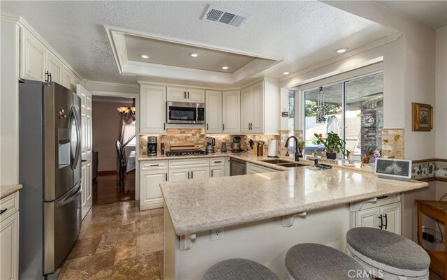 28852 Glenheather Dr, Highland, CA 92346 - kitchen with appliances with stainless steel finishes, a sink, a peninsula, stone finish flooring, and tasteful backsplash