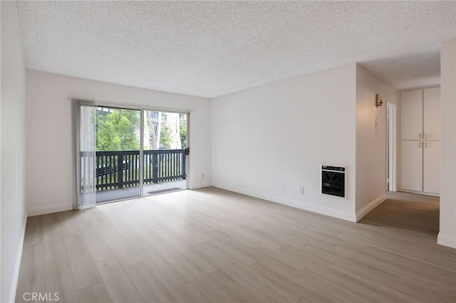 3602 W Estates Ln Unit 306, Rolling Hills Estates, CA 90274 - unfurnished room featuring heating unit, a textured ceiling, light wood finished floors, and baseboards
