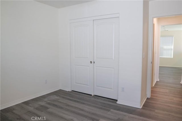 13936 Blossom Way, Eastvale, CA 92880 - unfurnished bedroom featuring dark wood-style floors, a closet, and baseboards