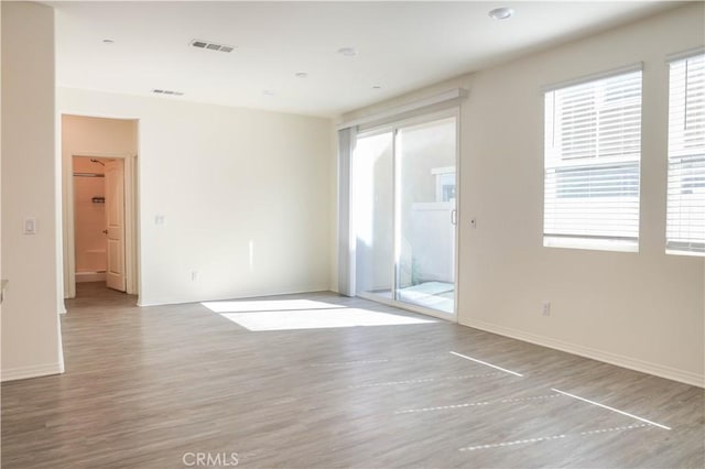 13936 Blossom Way, Eastvale, CA 92880 - unfurnished room featuring wood finished floors, healthy amount of natural light, and baseboards