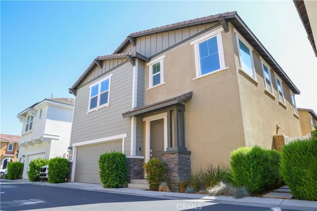 13936 Blossom Way, Eastvale, CA 92880 - view of side of property featuring an attached garage, stone siding, and board and batten siding