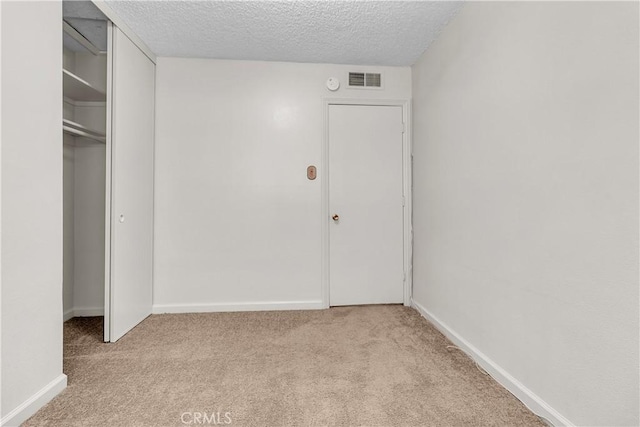560 E Mountain View St, Barstow, CA 92311 - unfurnished bedroom featuring light colored carpet, a textured ceiling, baseboards, and a closet
