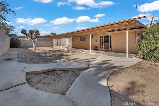 560 E Mountain View St, Barstow, CA 92311 - rear view of property with stucco siding, a fenced backyard, and a patio area