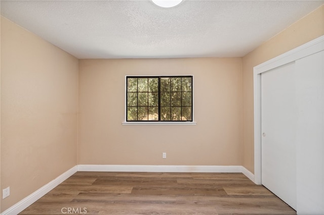 42490 Ranger Circle Way, Coarsegold, CA 93614 - unfurnished bedroom featuring wood finished floors, a closet, baseboards, and a textured ceiling