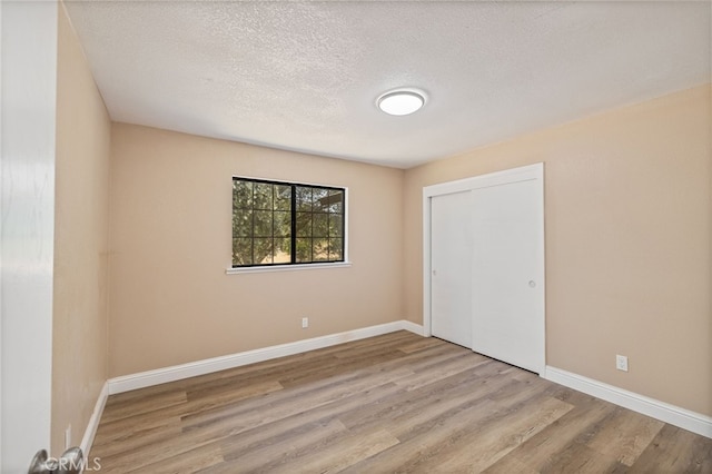 42490 Ranger Circle Way, Coarsegold, CA 93614 - unfurnished bedroom featuring wood finished floors, baseboards, a textured ceiling, and a closet