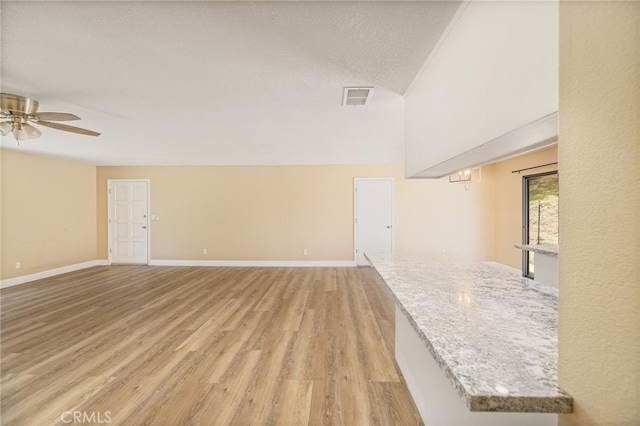 42490 Ranger Circle Way, Coarsegold, CA 93614 - unfurnished living room featuring light wood-style flooring, ceiling fan, baseboards, and a textured ceiling