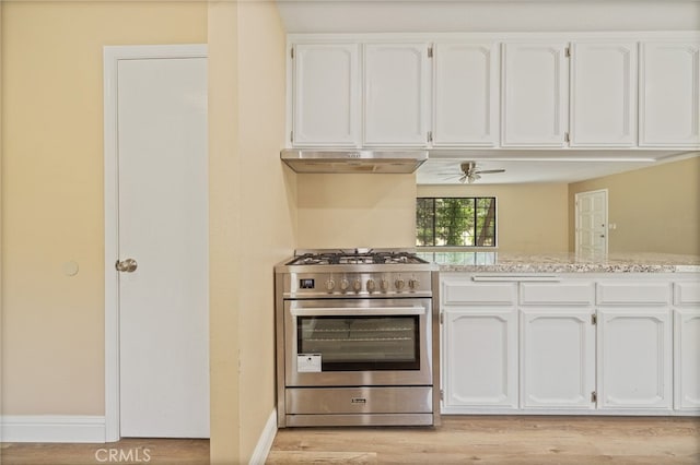42490 Ranger Circle Way, Coarsegold, CA 93614 - kitchen with stainless steel range with gas stovetop, under cabinet range hood, white cabinetry, light wood-style floors, and baseboards