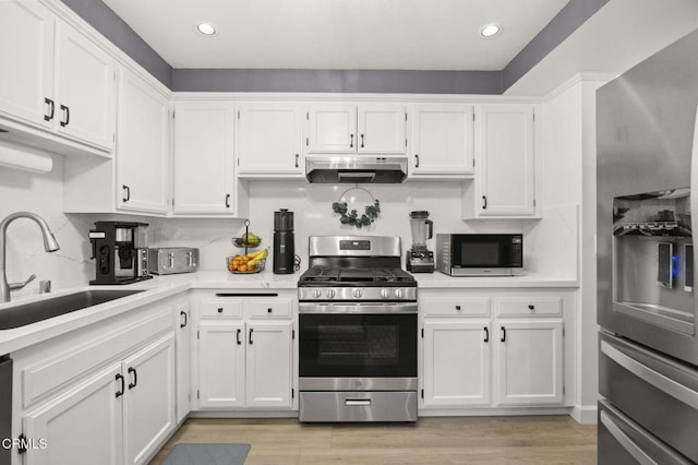 2328 N H St, Oxnard, CA 93036 - kitchen featuring appliances with stainless steel finishes, under cabinet range hood, a sink, white cabinets, and recessed lighting