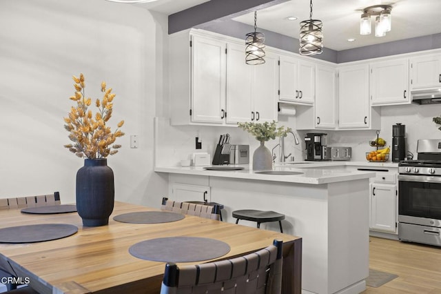 2328 N H St, Oxnard, CA 93036 - kitchen featuring gas range, a sink, white cabinets, a peninsula, and recessed lighting