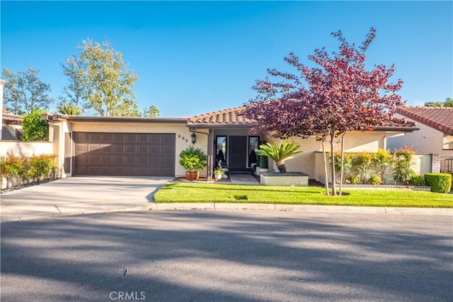 890 El Mirador, Upland, CA 91784 - view of front facade with stucco siding, a garage, driveway, and a tiled roof