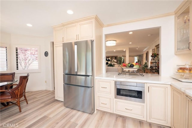 890 El Mirador, Upland, CA 91784 - kitchen featuring freestanding refrigerator, cream cabinetry, ornamental molding, light countertops, and light wood-type flooring