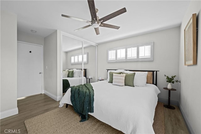bedroom featuring wood finished floors, baseboards, a closet, and ceiling fan