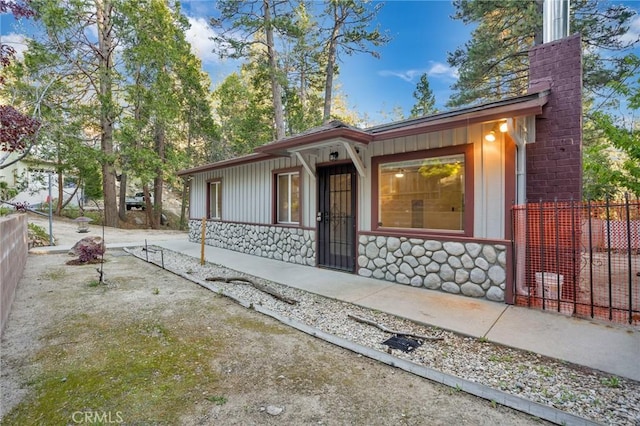 32159 Cove Cir, Running Springs, CA 92382 - view of front of home with stone siding, a porch, a chimney, and board and batten siding