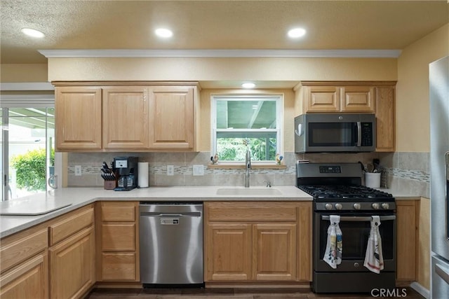 253 Gurnsey Dr, Red Bluff, CA 96080 - kitchen with appliances with stainless steel finishes, a sink, light countertops, backsplash, and crown molding