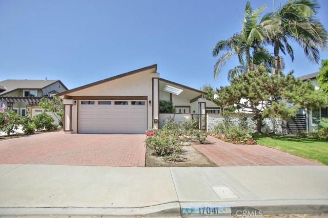 17041 Malta Cir, Huntington Beach, CA 92649 - view of front of home featuring decorative driveway, an attached garage, fence, and stucco siding