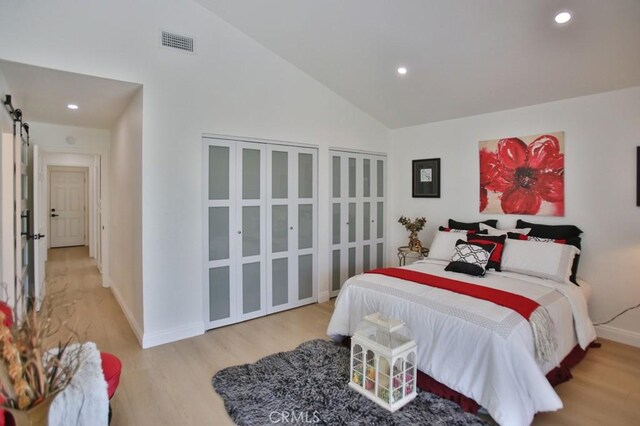 17041 Malta Cir, Huntington Beach, CA 92649 - bedroom featuring wood finished floors, recessed lighting, baseboards, a barn door, and high vaulted ceiling