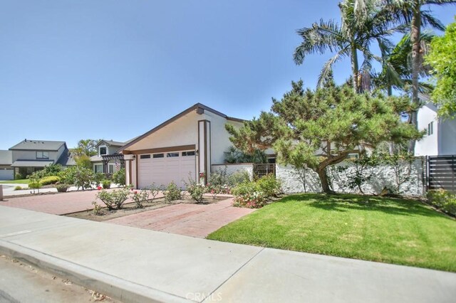 17041 Malta Cir, Huntington Beach, CA 92649 - view of front facade with a front yard, a garage, driveway, and stucco siding