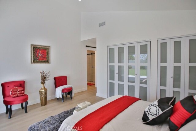 17041 Malta Cir, Huntington Beach, CA 92649 - bedroom featuring wood finished floors, a high ceiling, baseboards, and two closets