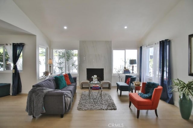 17041 Malta Cir, Huntington Beach, CA 92649 - living area featuring vaulted ceiling, light wood-type flooring, recessed lighting, plenty of natural light, and a large fireplace