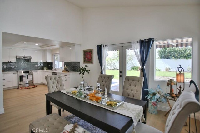 17041 Malta Cir, Huntington Beach, CA 92649 - dining room featuring light wood-style flooring, french doors, a tray ceiling, baseboards, and recessed lighting