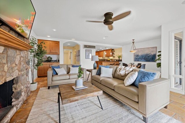 515 S Sierra Ave Unit 130, Solana Beach, CA 92075 - living room featuring a ceiling fan, arched walkways, a fireplace, recessed lighting, and stone tile flooring