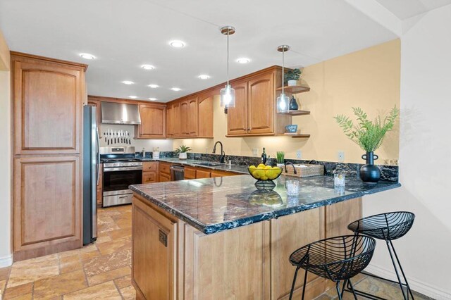 515 S Sierra Ave Unit 130, Solana Beach, CA 92075 - kitchen with stainless steel appliances, wall chimney range hood, a peninsula, light stone finish floors, and a breakfast bar